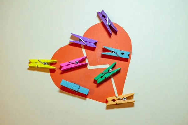 Clothespins on broken heart. Broken heart concept, or putting pieces back together. Place for your text