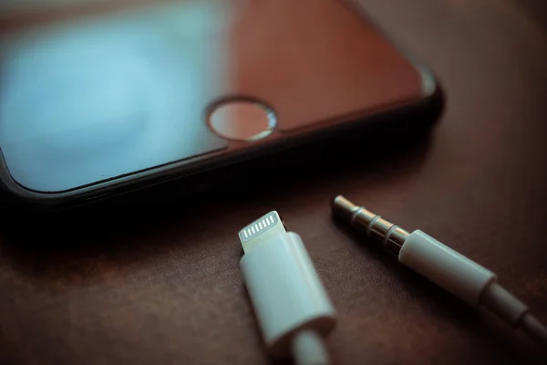 Nizhyn, Ukrayna / 26 Kasım 2019: iphone 7 Plus ve yıldırımlı kulaklıkların yakın plan fotoğrafı ve 3.5 mm 'lik kriko çıktıları bir arada. Elma yeni yıldırım konsepti