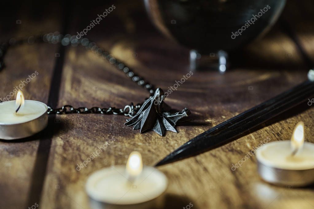 Nizhyn, Ukraine/ 22 December 2019: Closeup of Geralt's medallion, magic ball and knife on the table. New Netflix TV-series 