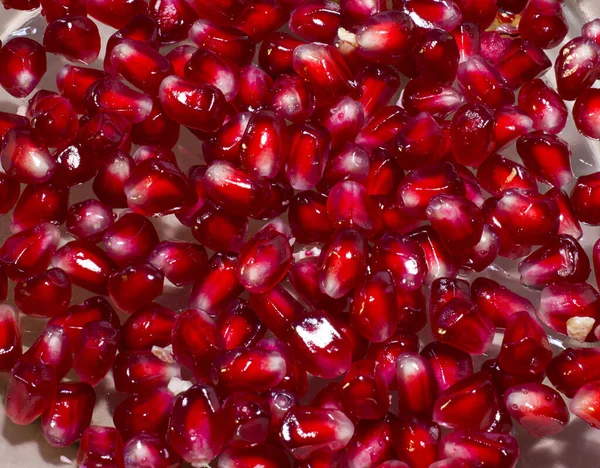 Grains of pomegranate fruit. Juicy ripe fruits of ruby seeds, close-up top view — Stock Photo, Image