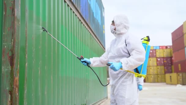 穿着防护服的人在货物容器上喷洒消毒剂 以防止考拉病毒的蔓延 — 图库视频影像