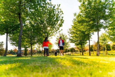 Korumalı maske takan genç bir çift, Corona virüsü salgını yüzünden dışarıda köpekle birlikte yürüyorlar.