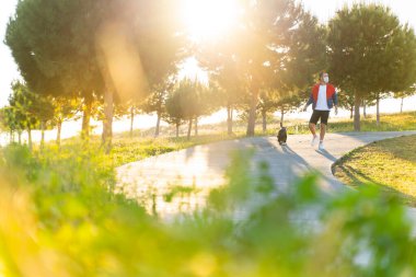 Korumalı maske takan bir adam, Corona virüsü salgını yüzünden dışarıda köpekle tek başına yürüyor.