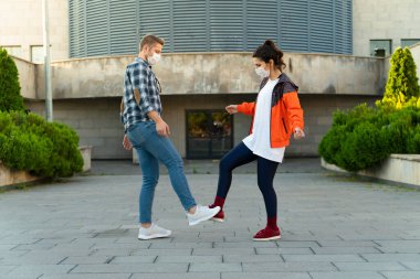 Genç çift ayaklarıyla selamlıyor. Coronavirüs salgını. Covid 19 konsepti. Coronavirus önleme.