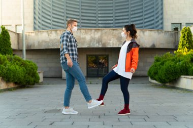 Genç çift ayaklarıyla selamlıyor. Coronavirüs salgını. Covid 19 konsepti. Coronavirus önleme.