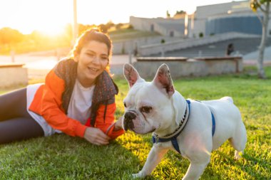 Korumalı maske takan bir kadın, Corona virüsü salgını yüzünden dışarıda köpekle birlikte yürüyor.