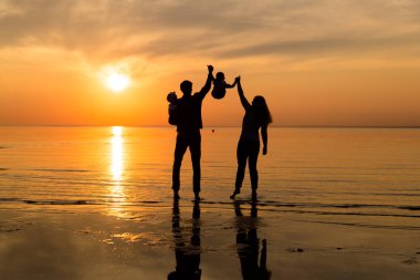 Aile gün batımında sahilde