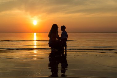 Aile gün batımında sahilde
