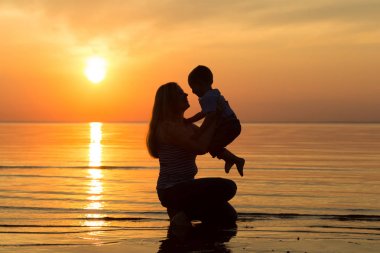 Aile gün batımında sahilde