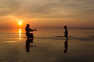 Aile gün batımında sahilde