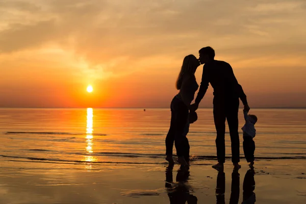 日没時にビーチで家族が — ストック写真