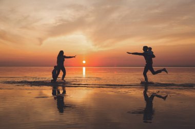 Aile gün batımında sahilde