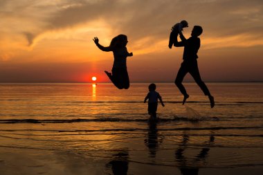 Aile gün batımında sahilde