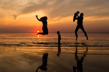 Aile gün batımında sahilde