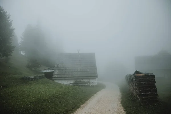 Gravel Pad Tussen Berghutten Tijdens Mistige Ochtend Met Hoop Hout — Stockfoto