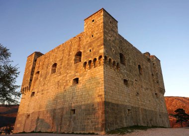 Hırvatistan 'ın Senj kentinin batan güneşle aydınlatılan ortaçağ kale kulesi