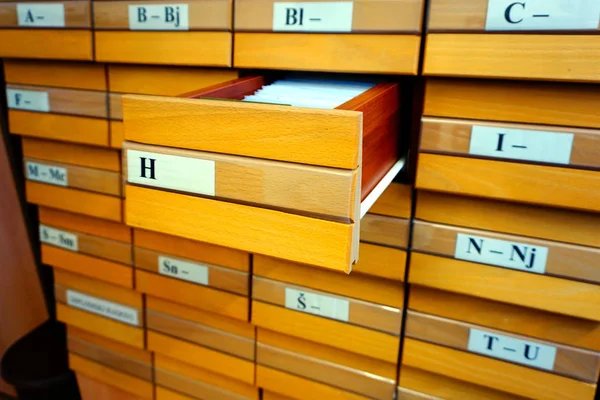 Catálogo de madeira com uma gaveta aberta de letras f e documentos nele — Fotografia de Stock