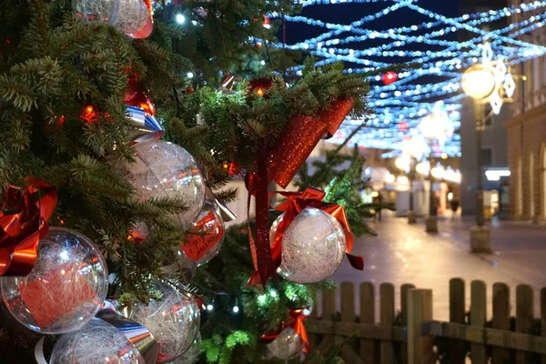 Geceleri sokağın ortasında toplarla süslenmiş bir Noel ağacı dalı. — Stok fotoğraf