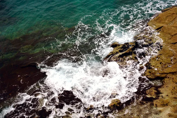 Onde bianche come una schiuma tra la superficie del mare e la costa spruzza la costa — Foto Stock