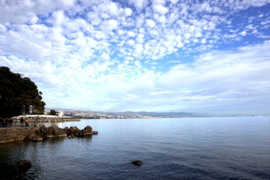 Rijeka kenti yakınlarındaki Hırvat turistik kenti Opatija 'da deniz kenarında yürüyüş yolu bulunan bir deniz manzarası