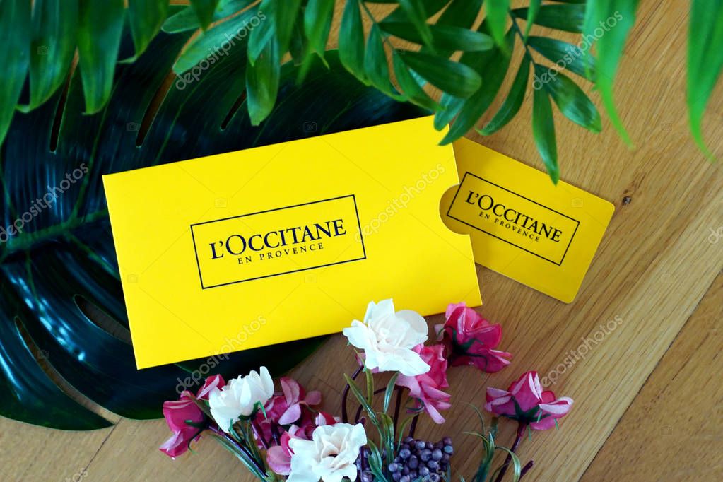 Croatia, Rijeka, January 6th, 2020. Loccitane en Provence French cosmetic gift card for shopping natural and organic cosmetic for skincare, hair and body care on the wooden and flower background