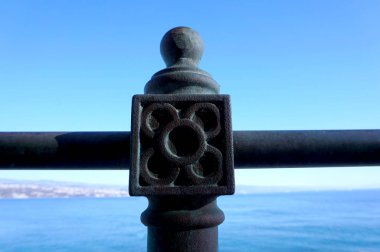 2020 yılında Avrupa kültür başkenti Rijeka yakınlarındaki Hırvatistan 'ın Kvarner bölgesindeki Opatija kasabasında deniz kenarındaki gezinti alanında demir bir çitin üzerinde yer alan Lungomare metal tutucusu.