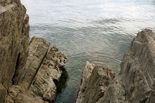 Vista superior desde los afilados acantilados rocosos hacia la superficie del mar — Foto de Stock