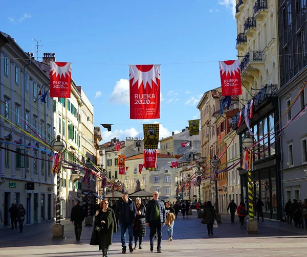 Calle principal de la ciudad croata de Rijeka con banderas con mensaje Capital de la cultura 2020 y Bandera de Carnaval — Foto de Stock