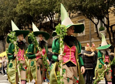 Rijeka, Hırvatistan, 23 Şubat 2020. Yeşil elbiseli orman perisi maskesi takmış kızlar karnaval geçidinde yavaşça yürüyorlar.