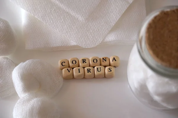 Kavramsal fotoğrafçılığın ortasında beyaz tonlarda Coronavirus kelimesi ve etrafındaki beyaz tıbbi malzemeler.