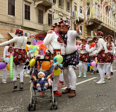 Karnavaldaki bebekler gibi maskeli yetişkinler.