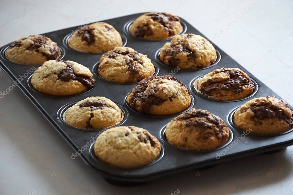 Softy fresh cupcakes with melted chocolate in a baking pan