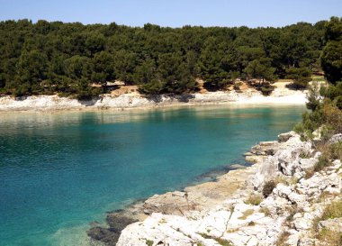 Hırvatistan 'ın Pula kentindeki güzel mavi ve turkuaz körfezdeki plaj güneşli bir bahar gününde