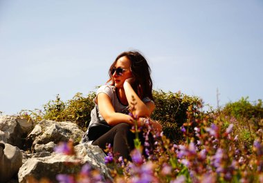 Çekici genç kızıl saçlı kadın rüzgarlı bir günde güneşin tadını çıkarıyor.