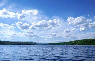 Mavi deniz yüzeyi üzerindeki bulutlar ve Hırvatistan 'daki Krk adasına giden köprü