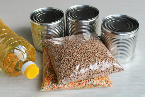 Food supplies crisis food stock for quarantine isolation period. Canned food, cereals, vegetable oil on the table. Food delivery, Donation, coronavirus.