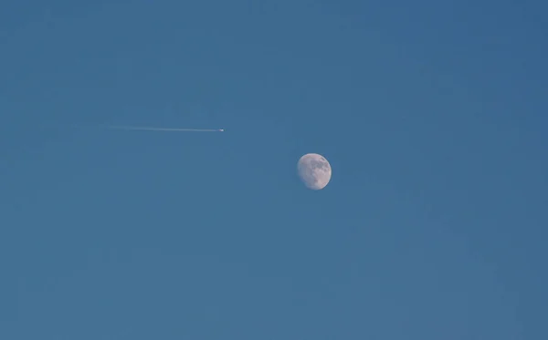 Airplane and moon at sunset