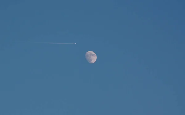 Airplane and moon at sunset