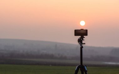 Akıllı telefon dağlarda gün batımını bekliyor.
