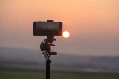 Akıllı telefon dağlarda gün batımını bekliyor.