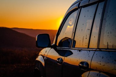 SUV, Karpatlar 'la gün batımında seyahat ediyor.