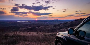 SUV, Karpatlar 'la gün batımında seyahat ediyor.