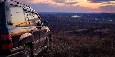 SUV, Karpatlar 'la gün batımında seyahat ediyor.