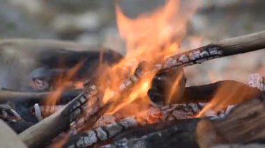 Şiddetli bir rüzgarla nehir kıyısında kamp ateşi