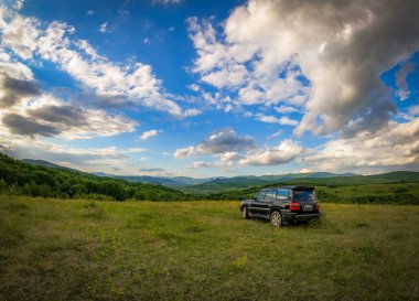 Karpat dağlarında bahar manzarası bir SUV ile