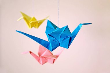 Barışın sembolü, inanç, kağıt renkli turnalar. Origami, mavi, sarı, mor, pembe