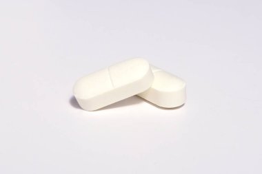 Beyaz arka plana yayılmış gölgeli beyaz haplara odaklan. Küresel sağlık hizmeti kavramı. Antibiyotik ilaç direnci. Anti mikrobik haplar makro. İlaç endüstrisi..