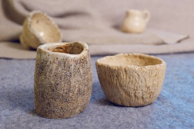 Kiev, Ukrayna. 10 Ocak 2020. Modern çömlekçilik. Dekoratif seramik, kil plaka. El yapımı hafif çömlek. Seramik seti, kâseler, arka planda duran bardak..