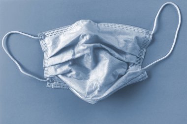 Mavi arka planda koruyucu maske. Tek kullanımlık yüz maskesi ağız ve burnu kapatır. Sağlık sigortası Coronavirus karantinası, hijyen konsepti. Koronavirüsü önle