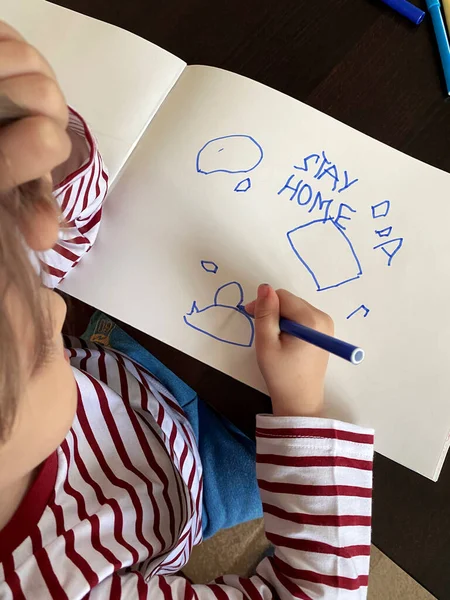 Küçük çocuğun eli çizimleri gösteriyor. Üst Manzara, bu yazılı evde kal